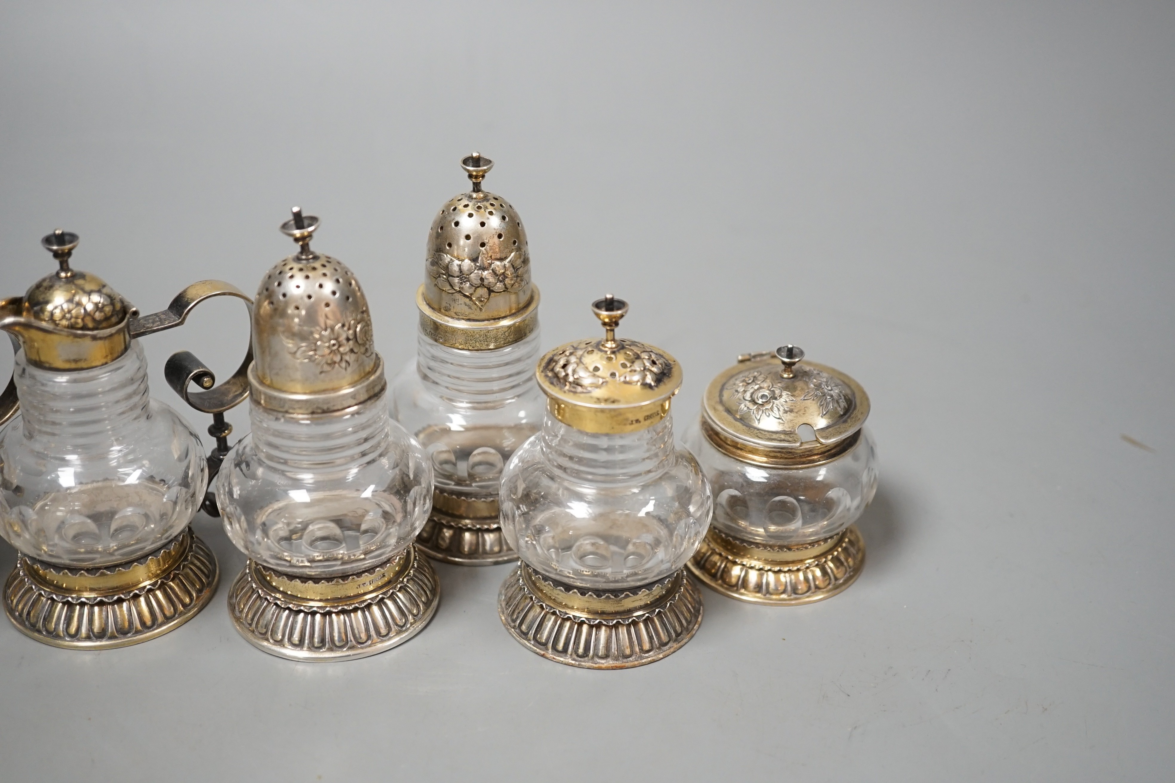 A late 19th/early 20th century Norwegian 830 standard gilt white metal mounted glass six piece cruet set, possibly by J. Tostrup, two pieces unmarked, tallest 97mm.